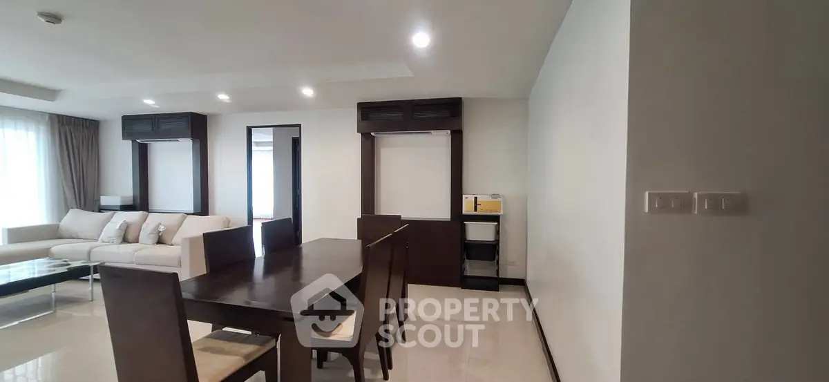 Spacious modern living and dining area with elegant furniture and ample natural light.