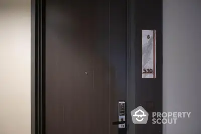 Modern apartment entrance with electronic lock and room number