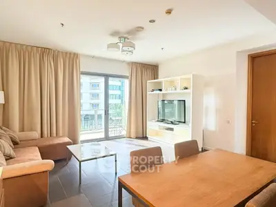 Spacious living room with modern furniture and large windows offering natural light and a view of the city.