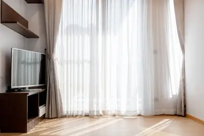 Bright living room with large window and modern TV setup