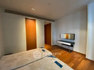 Spacious bedroom with wooden flooring and modern furniture, ideal for comfort and style.