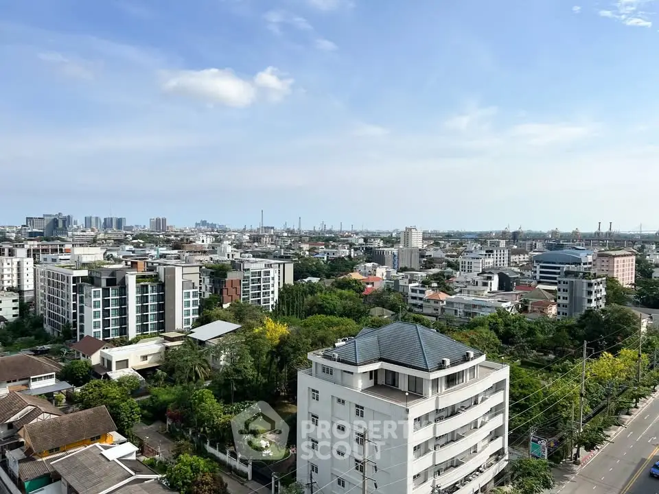 Stunning cityscape view showcasing modern residential buildings and lush greenery under a clear blue sky.
