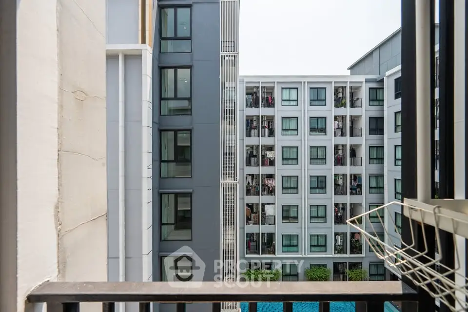 Modern apartment building exterior with pool view from balcony