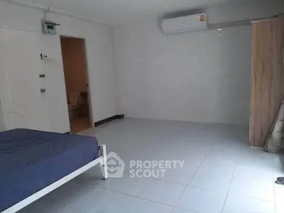 Spacious bedroom with minimalist design and air conditioning, perfect for comfort and relaxation.