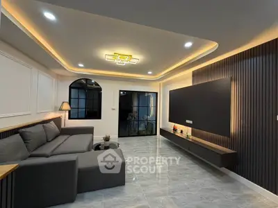 Modern living room with sleek design, recessed lighting, and large sectional sofa in a stylish apartment.