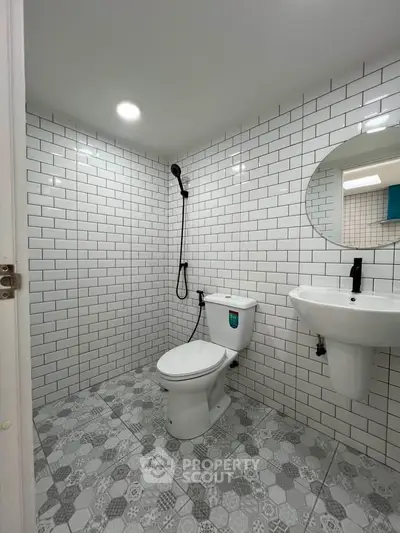 Modern bathroom with white subway tiles and geometric floor tiles