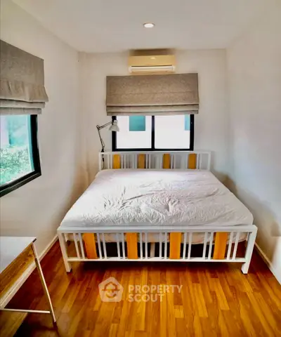 Cozy bedroom with wooden flooring and natural light