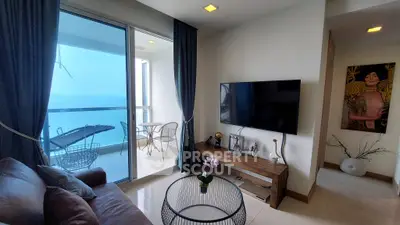 Modern living room with balcony and sea view, featuring stylish decor and comfortable seating.