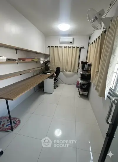 Spacious study room with modern desk and ample shelving, perfect for productivity.