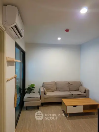 Cozy living room with modern sofa and air conditioning, perfect for relaxation.