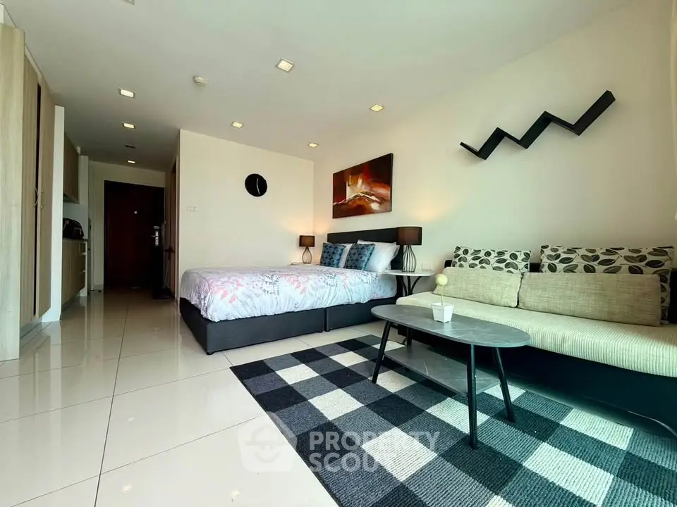 Modern studio apartment with stylish decor and open layout, featuring a cozy bed and chic living area.