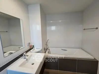 Modern bathroom with sleek bathtub and stylish sink in contemporary home.