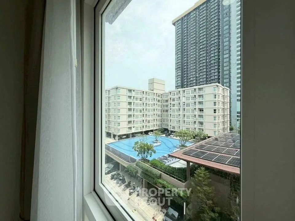 Stunning view of modern apartment complex with pool from window