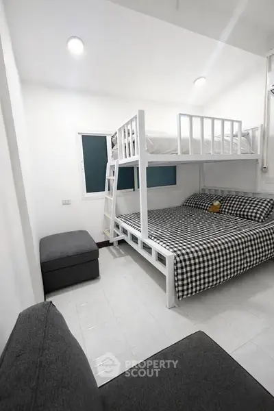 Modern bedroom with bunk bed and stylish decor, perfect for maximizing space in urban living.