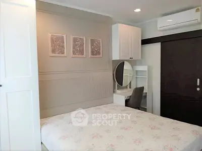 Cozy bedroom with elegant decor, featuring a built-in wardrobe and a stylish study nook.