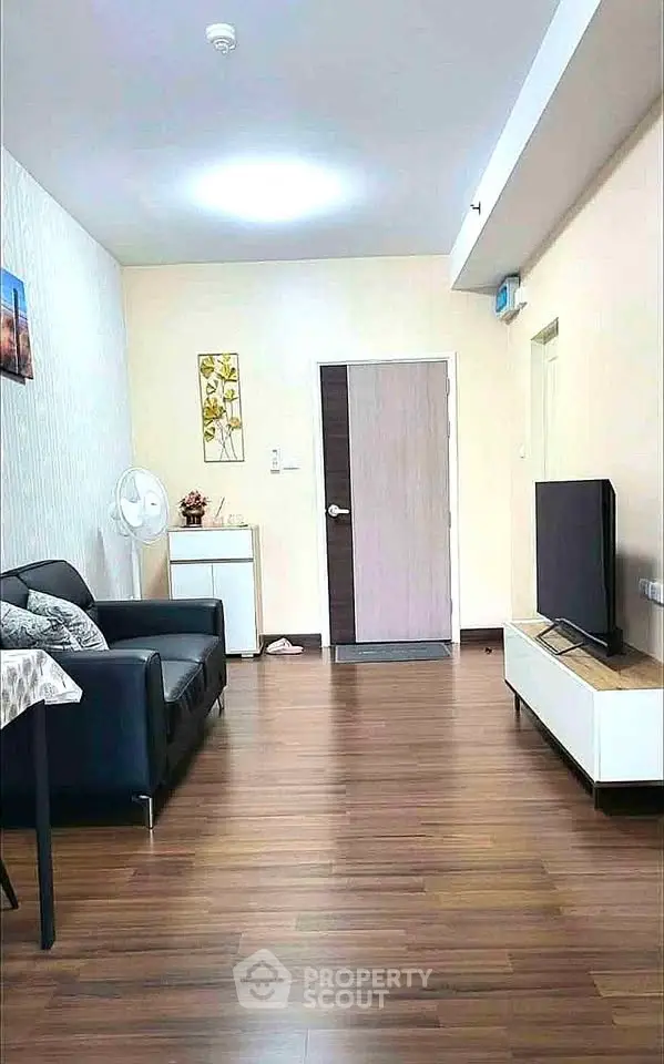 Modern living room with sleek furniture and wooden flooring, perfect for cozy gatherings.