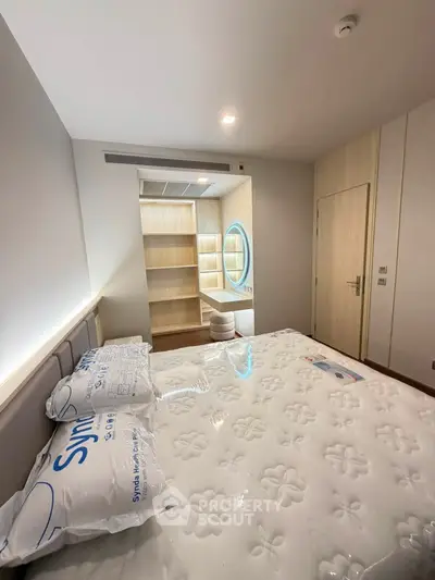Modern bedroom with stylish decor and built-in storage, featuring a cozy ambiance and elegant lighting.