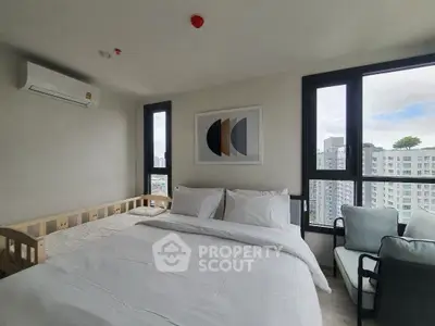 Modern bedroom with large windows and stylish decor in a high-rise apartment.