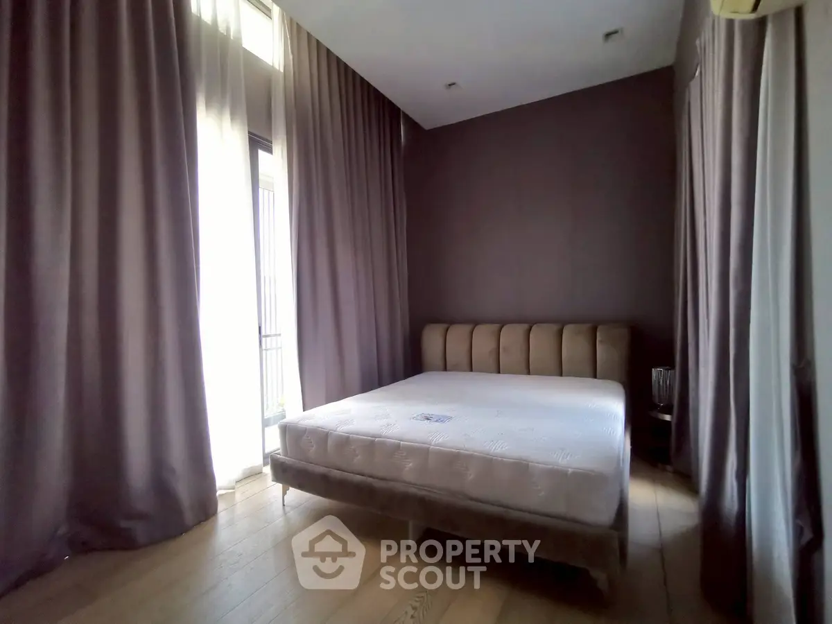 Spacious bedroom with large windows and elegant curtains