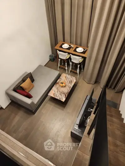 Modern loft-style living room with elegant decor and dining area, featuring a cozy sofa and stylish wooden flooring.
