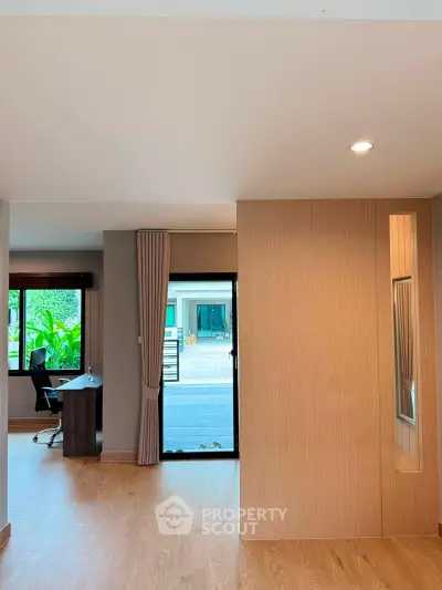 Spacious modern living area with wooden flooring and large window view