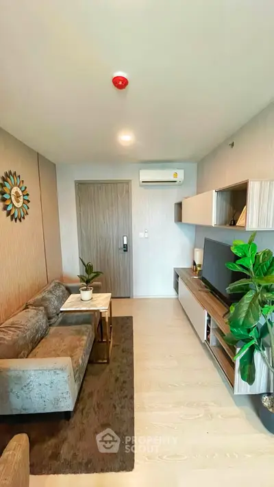 Modern living room with stylish furniture and wall-mounted TV in a cozy apartment.