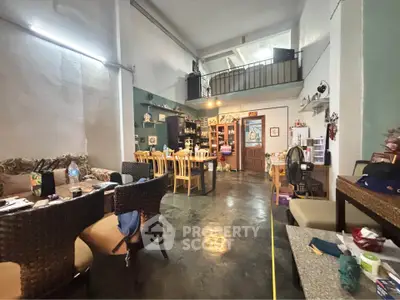 Charming open-plan living room with high ceilings and mezzanine, perfect for cozy gatherings.