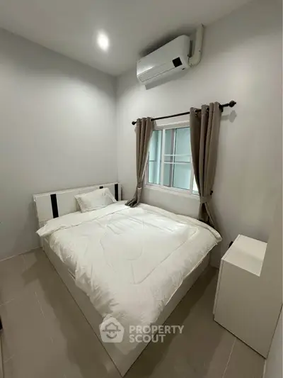 Cozy bedroom with modern air conditioning and natural light, perfect for restful nights.