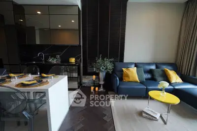 Modern open-layout living room with sleek kitchen, stylish decor, and cozy seating area.