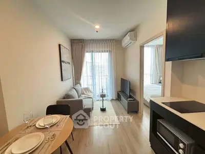Modern living room with cozy sofa, dining area, and natural light from balcony.