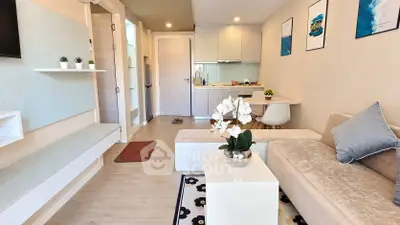 Modern living room with open kitchen, stylish decor, and cozy seating area in a contemporary apartment.
