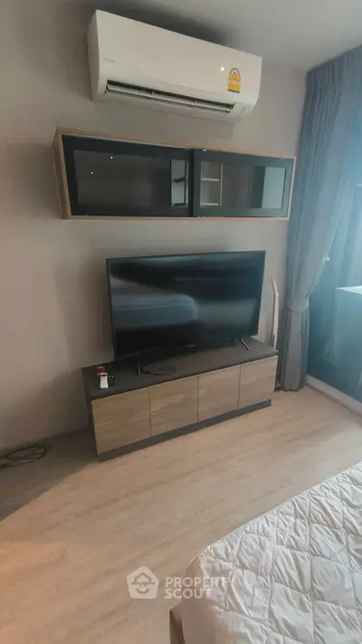 Modern bedroom with sleek TV unit and air conditioning