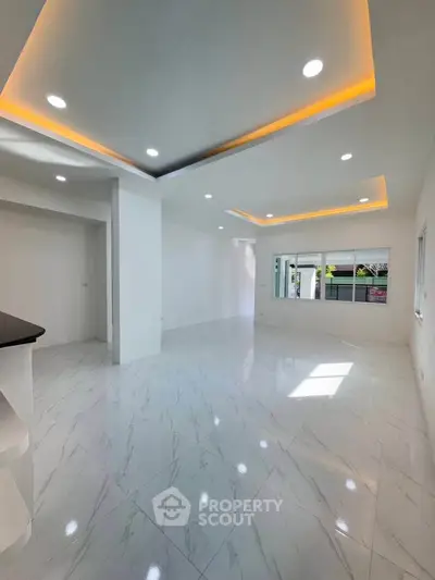 Spacious modern living room with elegant ceiling lights and large windows