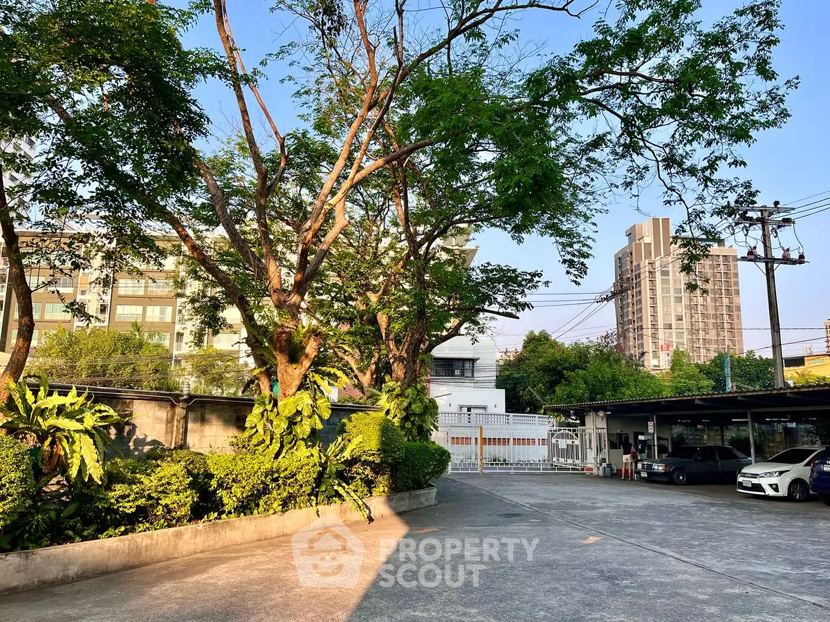 Spacious urban parking area with lush greenery and cityscape views.