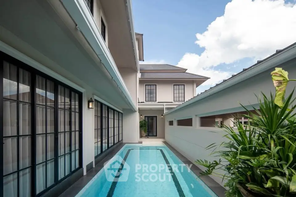 Luxurious modern home with sleek private pool and elegant architecture under a clear blue sky.