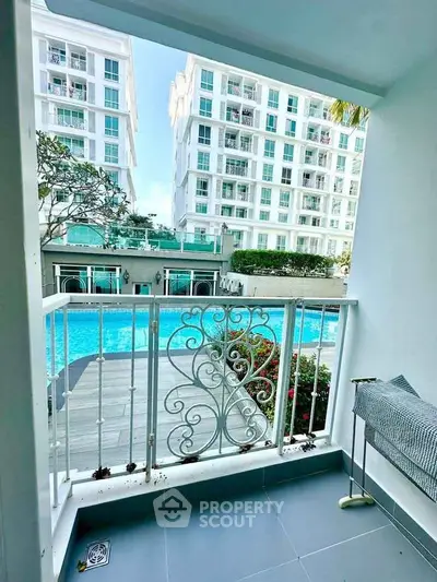 Charming balcony view overlooking a luxurious pool in a modern apartment complex.