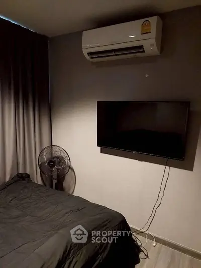 Cozy bedroom with air conditioning and wall-mounted TV, perfect for relaxation.