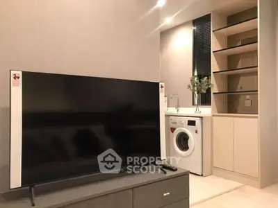 Modern living room with sleek TV and built-in washing machine in stylish apartment.