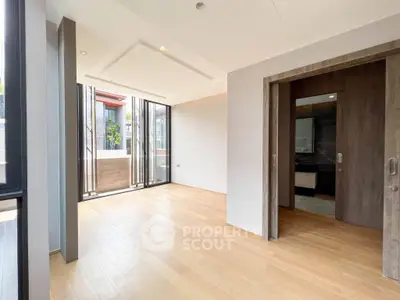 Spacious modern living area with wooden flooring and large windows