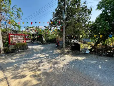 Charming outdoor entrance with festive flags and lush greenery, perfect for welcoming guests.