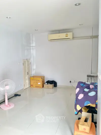 Spacious room with air conditioning and tiled flooring, ideal for customization.