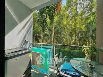 Charming balcony with lush green view, perfect for relaxation and outdoor dining.