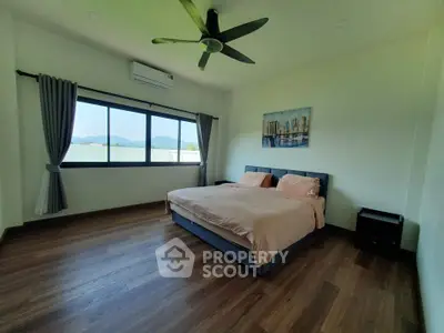 Spacious bedroom with large window and modern decor