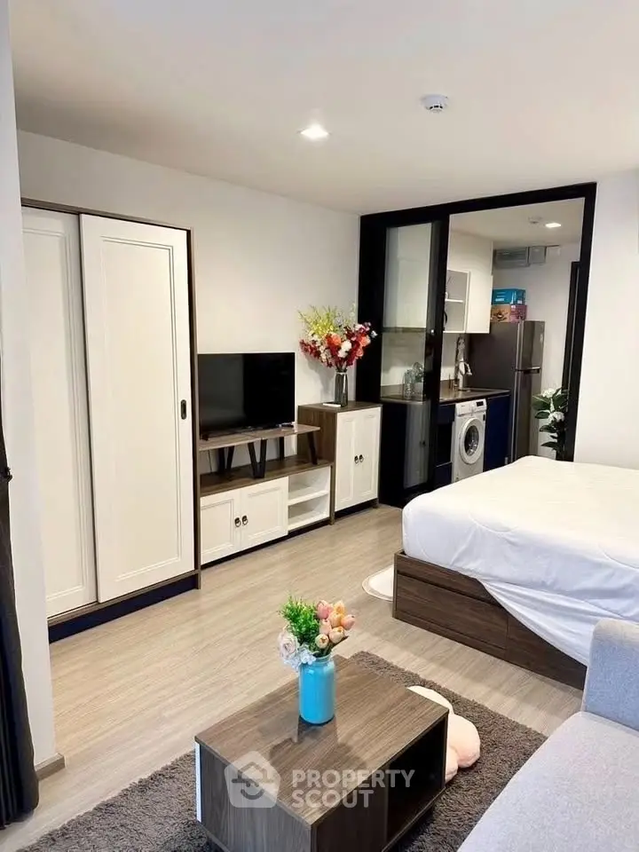 Modern studio apartment with open layout, featuring a cozy living area, compact kitchen, and stylish decor.