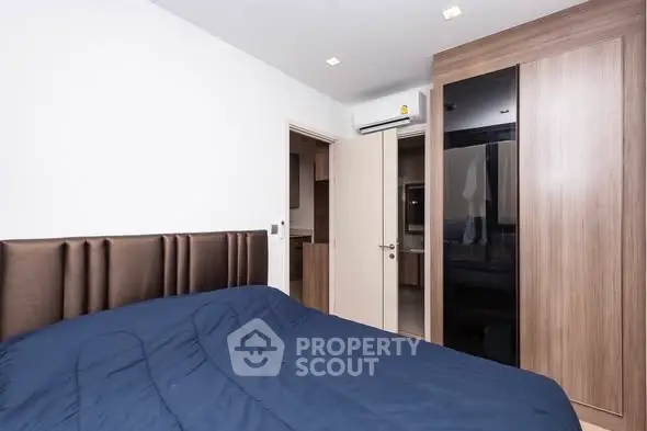 Modern bedroom with sleek wardrobe and cozy bedding in a stylish apartment.