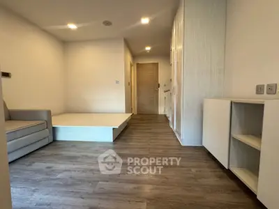 Modern minimalist living room with wooden flooring and built-in storage
