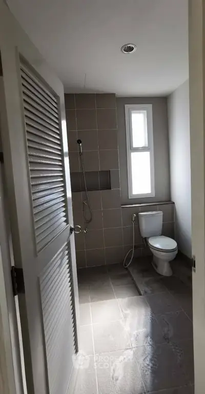Modern bathroom with sleek tile design and natural light from window