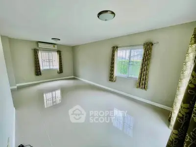 Spacious empty room with glossy tiled floor and large windows, perfect for customization.