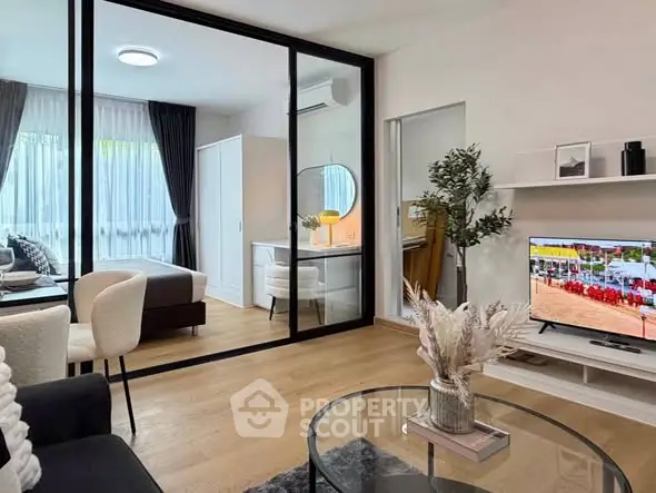 Modern living room with glass partition, stylish decor, and natural light