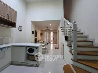 Modern interior with open kitchen and staircase leading to upper level